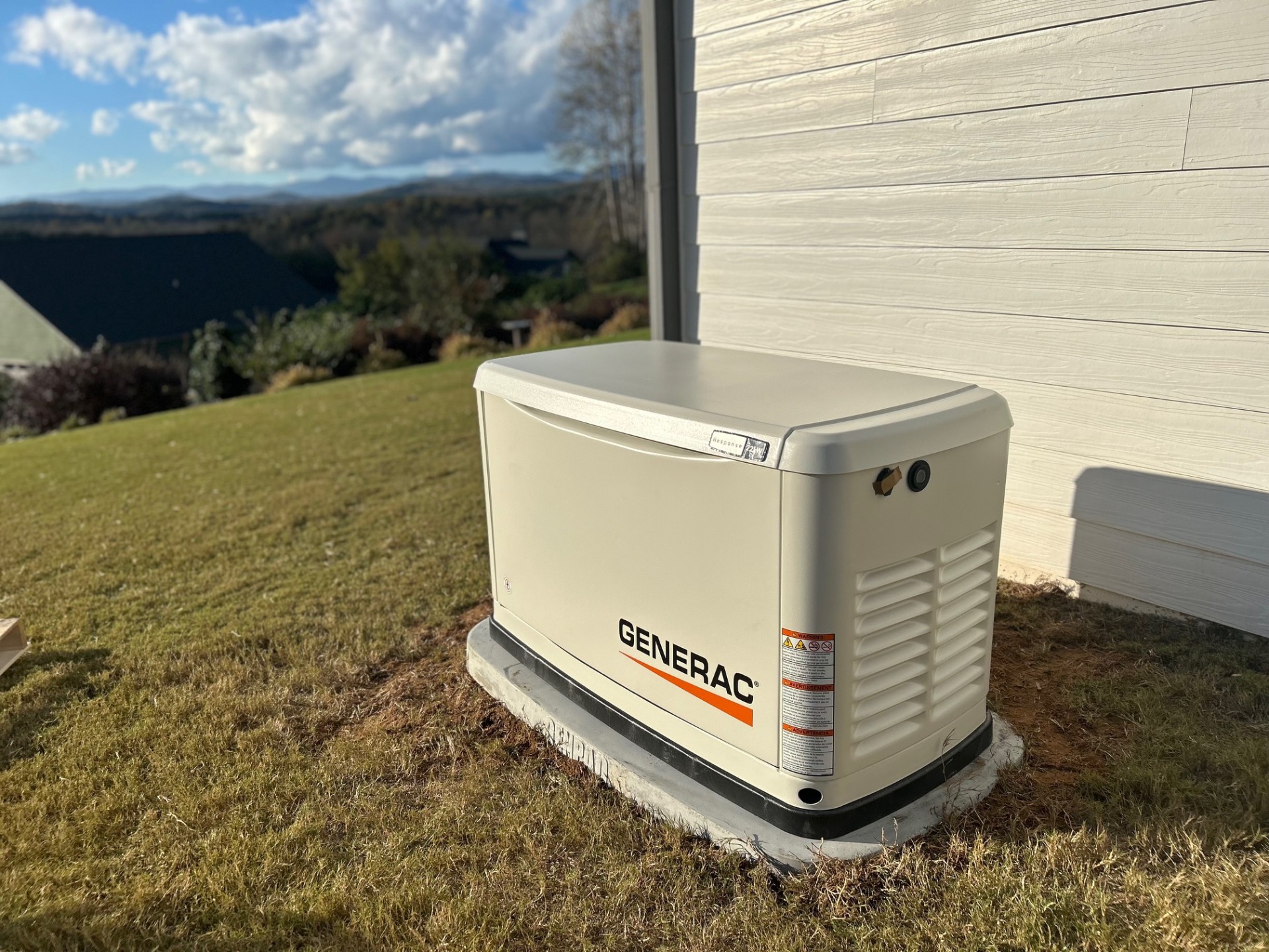 Standby generator on a concrete pad with summer thunderstorms building over the Blue Ridge in Upstate South Carolina