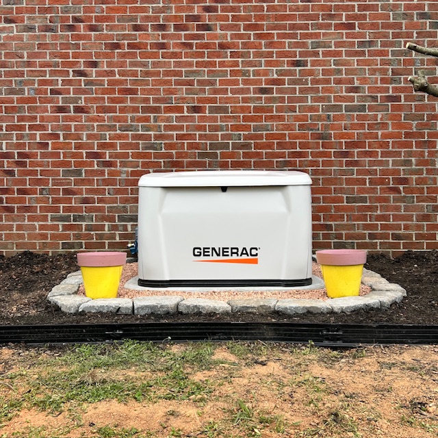 Finished home standby generator installed beside an Upstate South Carolina brick home, ready to carry the house when the power drops